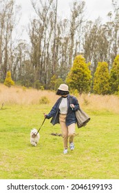 A Young Hispanic Woman Walking With Her Pet Dog Through Nature