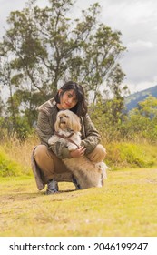 A Young Hispanic Woman Walking With Her Pet Dog Through Nature