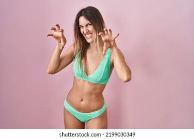 Young Hispanic Woman Wearing Bikini Over Pink Background Smiling Funny Doing Claw Gesture As Cat, Aggressive And Sexy Expression 