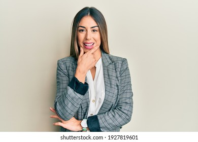 Young Hispanic Woman Wearing Business Clothes Looking Confident At The Camera Smiling With Crossed Arms And Hand Raised On Chin. Thinking Positive. 