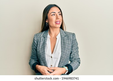 Young Hispanic Woman Wearing Business Clothes Looking Away To Side With Smile On Face, Natural Expression. Laughing Confident. 