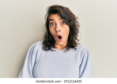 Young Hispanic Woman Wearing Casual Winter Sweater Afraid And Shocked With Surprise Expression, Fear And Excited Face. 