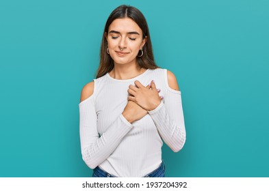 Young Hispanic Woman Wearing Casual Clothes Smiling With Hands On Chest With Closed Eyes And Grateful Gesture On Face. Health Concept. 