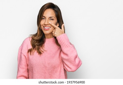 Young hispanic woman wearing casual clothes pointing with hand finger to face and nose, smiling cheerful. beauty concept 