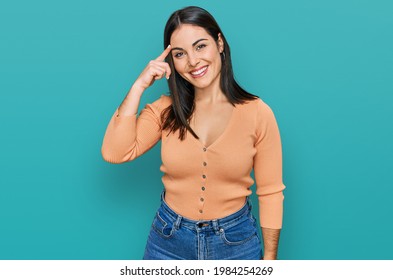 Young Hispanic Woman Wearing Casual Clothes Smiling Pointing To Head With One Finger, Great Idea Or Thought, Good Memory 