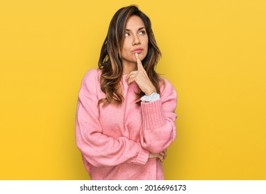 Young Hispanic Woman Wearing Casual Clothes With Hand On Chin Thinking About Question, Pensive Expression. Smiling With Thoughtful Face. Doubt Concept. 