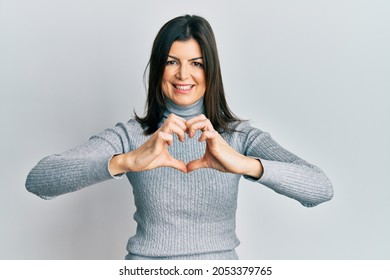 Young Hispanic Woman Wearing Casual Clothes Smiling In Love Doing Heart Symbol Shape With Hands. Romantic Concept. 