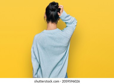 Young Hispanic Woman Wearing Casual Clothes Backwards Thinking About Doubt With Hand On Head 