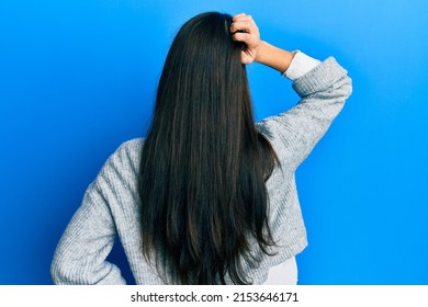 Young Hispanic Woman Wearing Casual Clothes Backwards Thinking About Doubt With Hand On Head 