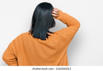 Young Hispanic Woman Wearing Casual Clothes Backwards Thinking About Doubt With Hand On Head 