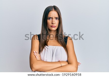 Young hispanic woman wearing casual clothes skeptic and nervous, disapproving expression on face with crossed arms. negative person. 