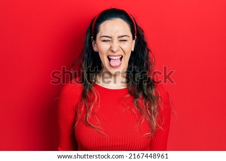 Young hispanic woman wearing casual clothes sticking tongue out happy with funny expression. emotion concept. 