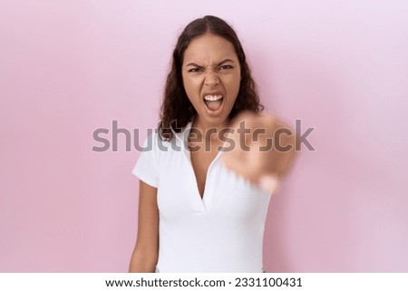 Young hispanic woman wearing casual white t shirt pointing displeased and frustrated to the camera, angry and furious with you 