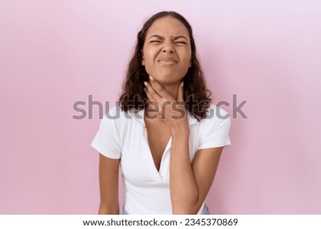 Young hispanic woman wearing casual white t shirt touching painful neck, sore throat for flu, clod and infection 