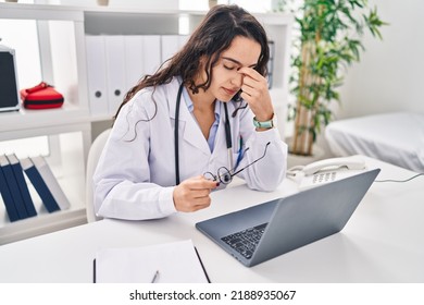 Young Hispanic Woman Wearing Doctor Uniform Stressed Working At Clinic