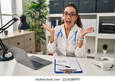 Young hispanic woman wearing doctor uniform and stethoscope celebrating crazy and amazed for success with arms raised and open eyes screaming excited. winner concept  - Shutterstock ID 2214288997