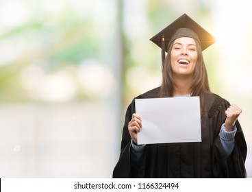 Young Hispanic Woman Wearing Graduated Uniform Holding Diploma Paper Screaming Proud And Celebrating Victory And Success Very Excited, Cheering Emotion