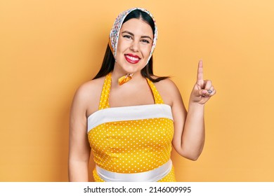 Young hispanic woman wearing pin up style smiling with an idea or question pointing finger up with happy face, number one 
