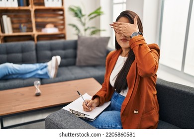 Young Hispanic Woman Working As Psychology Counselor Covering Eyes With Hand, Looking Serious And Sad. Sightless, Hiding And Rejection Concept 