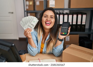 Young Hispanic Woman Working At Small Business Ecommerce Holding Money And Dataphone Smiling And Laughing Hard Out Loud Because Funny Crazy Joke. 