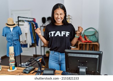 Young hispanic woman working as staff at retail boutique angry and mad screaming frustrated and furious, shouting with anger. rage and aggressive concept. 