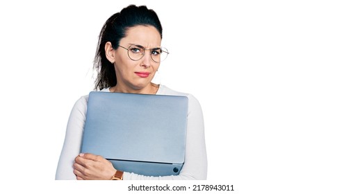 Young Hispanic Woman Working Using Computer Laptop Clueless And Confused Expression. Doubt Concept. 