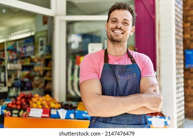 Young Hispanic Worker Wearing Apron Standing With Arms Crossed Gesture At The Fruit Store.