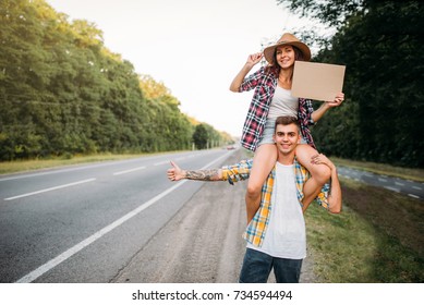 Young Hitchhiking Couple With Empty Cardboard