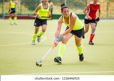 Young hockey player woman with ball in attack playing field hockey game