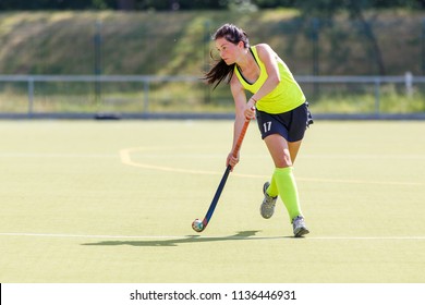 Young Hockey Player Woman With Ball In Attack Playing Field Hockey Game