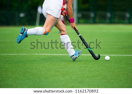 Young hockey player woman with ball in attack playing field hockey game