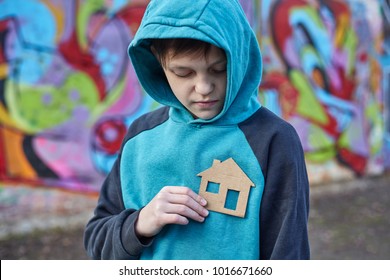 Young Homeless Boy Holding A Cardboard House