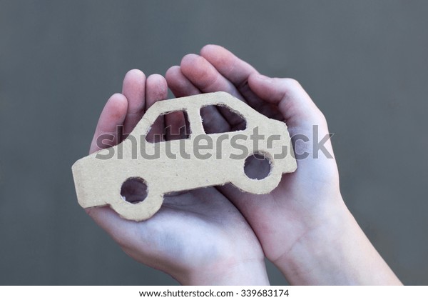 young homeless boy holds a cardboard car, dirty\
hand, dream concept