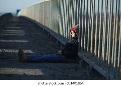 Young Homeless Boy Sleeping On The Bridge, Poverty, City, Street