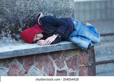 Young Homeless Boy Sleeping On The Street, Poverty, City,