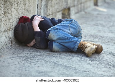 Young Homeless Boy Sleeping On The Bridge, Poverty, City, Street