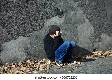 Young Homeless Boy Sleeping On The Street, Poverty, City