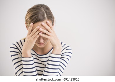 Young hopeless woman suffering from depression having nervous breakdown holding her head on isolated background, copy space