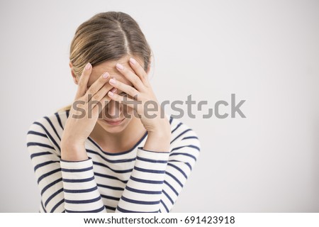 Young hopeless woman suffering from depression having nervous breakdown holding her head on isolated background, copy space