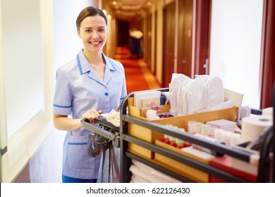 Young Hotel Staff Bringing Clean Towels And Other Supplies