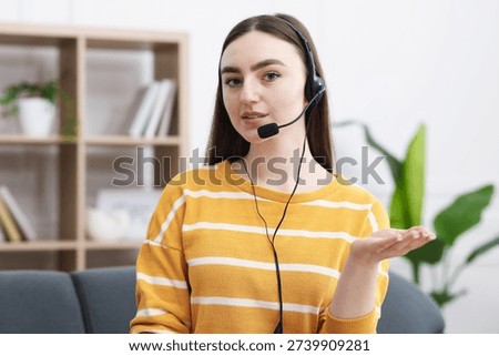 Young hotline operator in headset in office