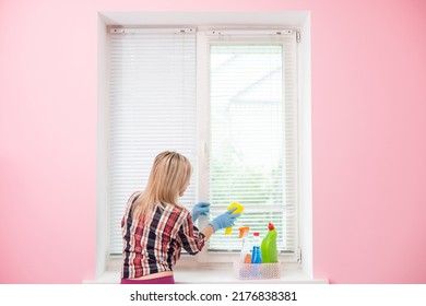 Young housekeeper washing window. woman doing professional house cleaning, providing sanitary service, closeup - Shutterstock ID 2176838381