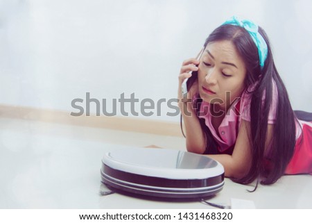 Young housewife, cleaning the house, spending time talking on the phone, taking care of the house, not having to exert tiredness, allowing the robot to vacuum, working automatically.
