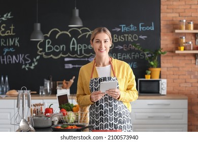 Young housewife with tablet computer cooking in kitchen at home - Powered by Shutterstock