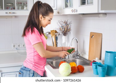 Young housewife washing fresh vegetables