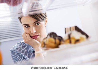 Young Hungry Woman In Front Of Refrigerator Craving Chocolate Pastries.