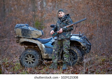 Young Hunter On A Quad Bike Searching For Game In The Forest