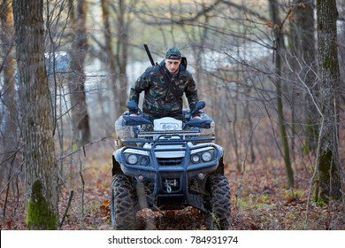 Young Hunter On A Quad Bike Searching For Game In The Forest