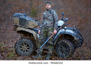 Young Hunter On A Quad Bike Searching For Game In The Forest