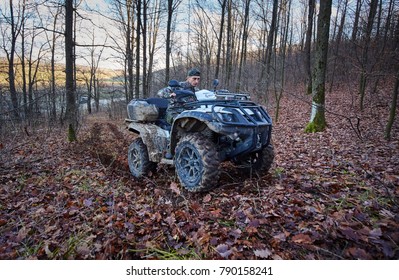 Young Hunter On A Quad Bike Searching For Game In The Forest